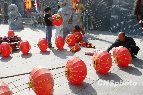 8月31日，河南省開封市天波楊府門口，工作人員在準(zhǔn)備懸掛大紅燈籠。隨著“十一”國慶節(jié)和“十一”旅游黃金周的臨近，古城開封的公園景點(diǎn)已早早開始備戰(zhàn)，營造喜慶祥和的旅游環(huán)境，迎接八方客人。 中新社發(fā) 李俊生 攝