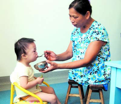 許月華在給孩子喂飯。劉炬 攝