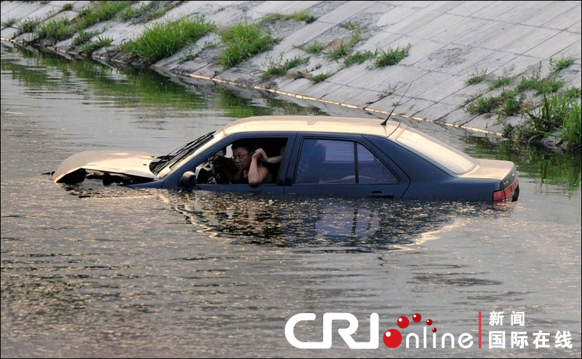 車(chē)沖入河中，依稀可見(jiàn)車(chē)中兩名男子正在打斗。