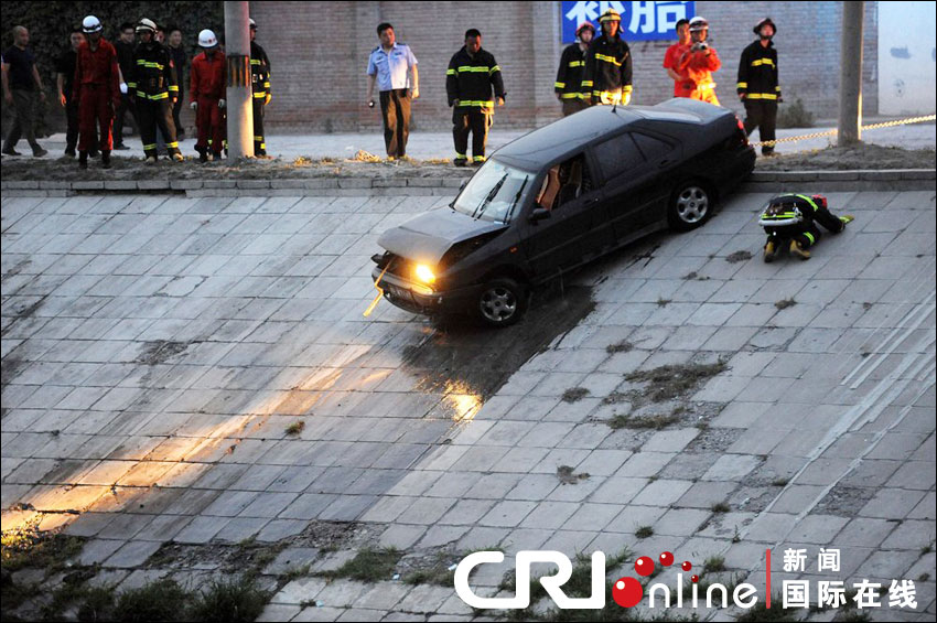 2012年6月17日下午，北京四元橋下方的西壩河輔路上，一輛轎車失控墜河中。消防員將轎車拖上岸。