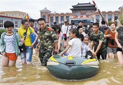 昨日，消防戰(zhàn)士在秦皇島市山海關(guān)火車站涉水運送旅客。當日，受持續(xù)強降雨影響，河北省秦皇島市海港區(qū)、山海關(guān)區(qū)等地出現(xiàn)內(nèi)澇，部分列車停運。 新華社發(fā)