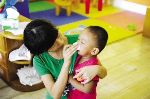 2012年9月3日，浙江一所幼兒園，老師幫孩子擦鼻涕。