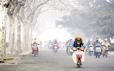 昨天上午，中原路，行人在霧霾中騎車出行，很多行人戴上了口罩。